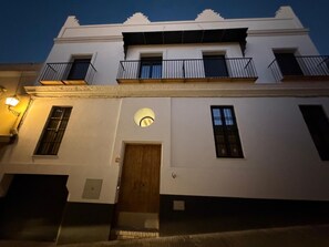 A white building with a wooden door, multiple windows, and a balcony with railings. - New Listing (Sanlúcar de Barrameda)