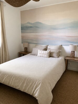 A bedroom with a large bed, two bedside tables, a wall painting, and a view of the outdoors. - New Listing (Barneville-Carteret)