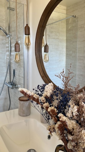 A bathroom with a round mirror, a sink, and hanging light fixtures. - New Listing (Barneville-Carteret)