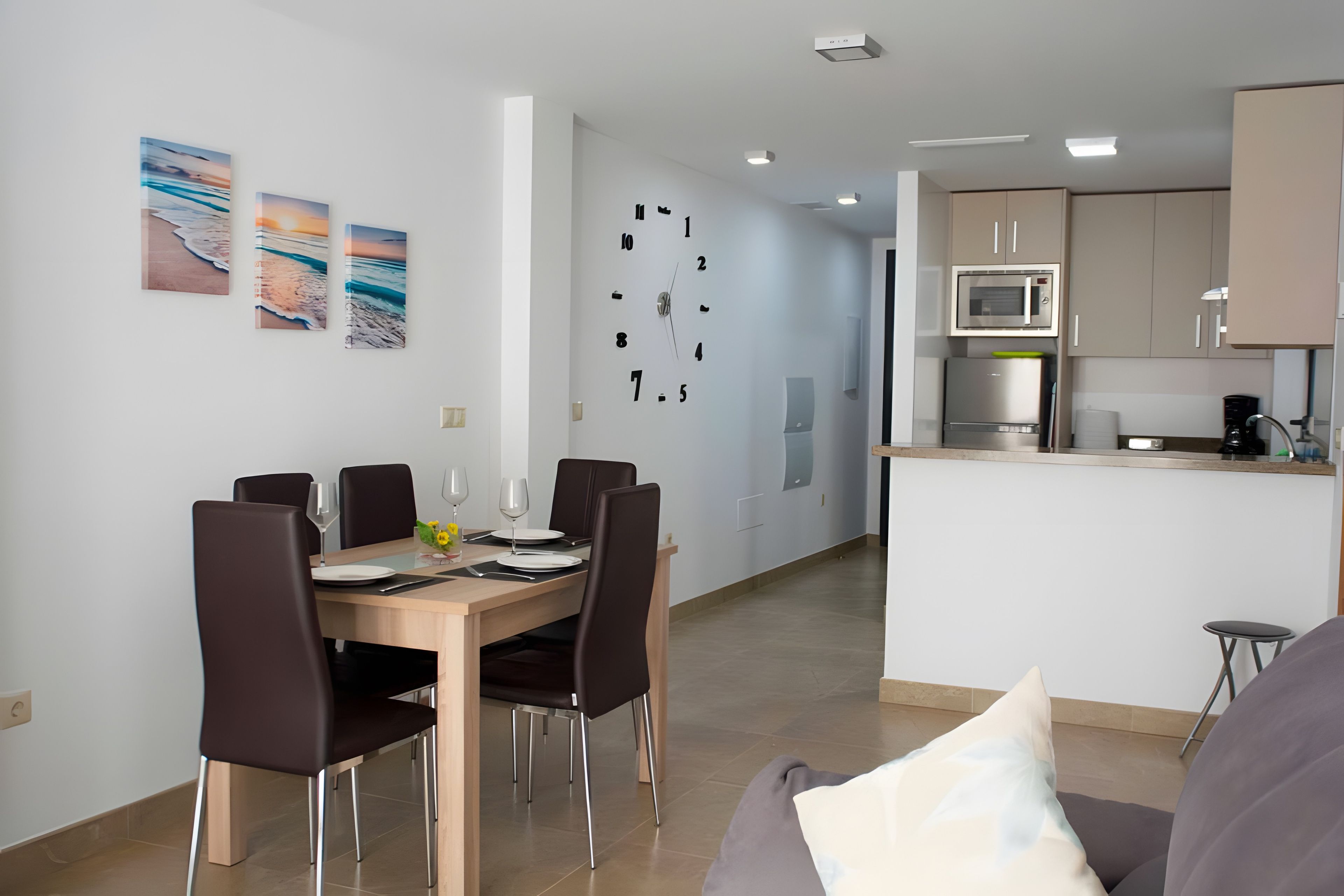 A modern kitchen with a built-in microwave and a coffee machine.