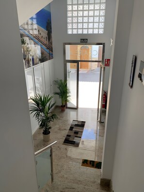 A hotel entrance with a glass door, a sign reading 'SALIDA,' and a fire extinguisher mounted on the wall. - Apartamento tranquilo con balcón y terraza en Carboneras, para 3 personas (Carboneras)