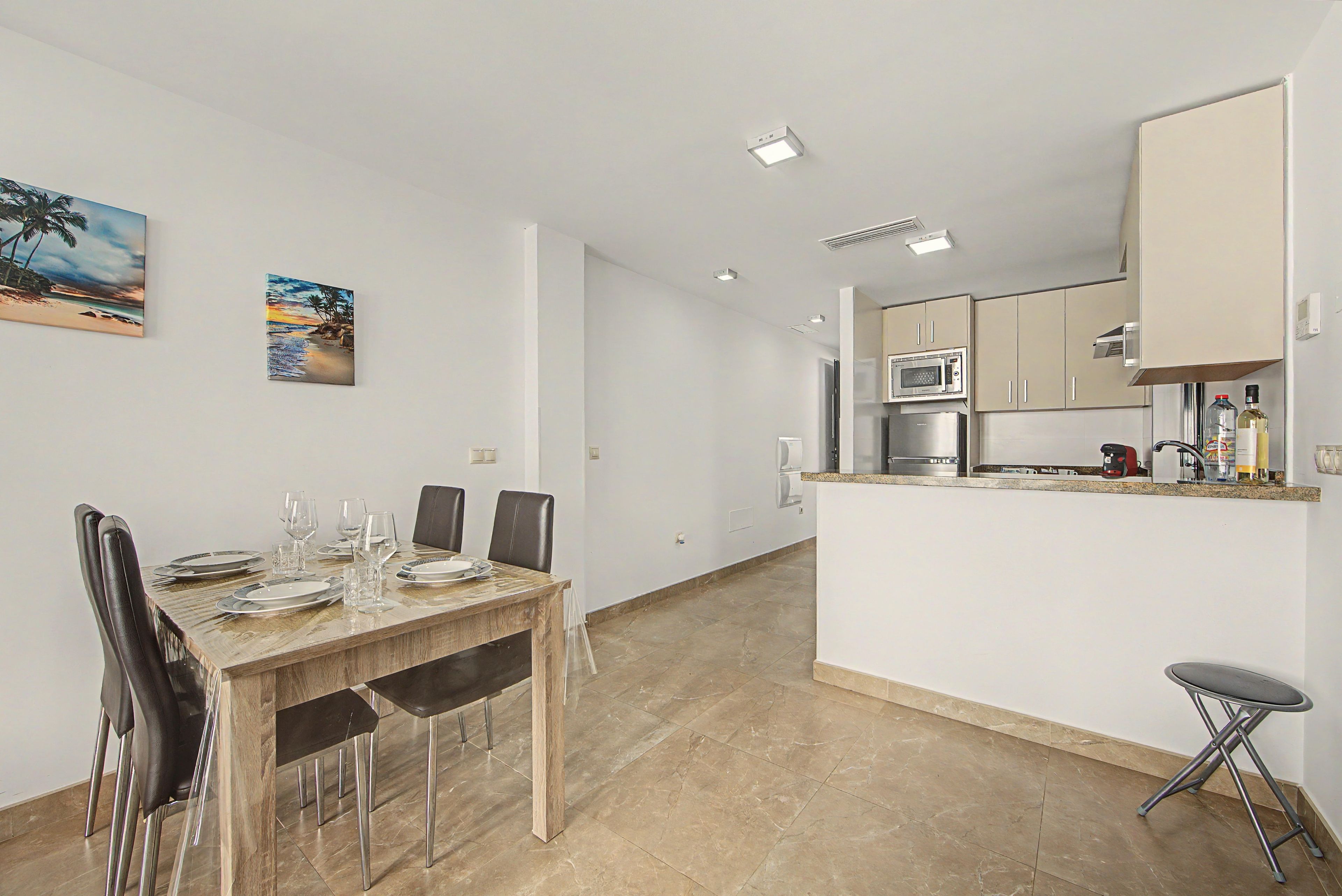 Eine moderne Küche mit Mikrowelle, Kühlschrank und einer kleinen Kochinsel mit Spüle.