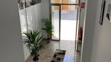A hotel entrance with a glass door, a sign reading 'SALIDA,' and a fire extinguisher mounted on the wall.