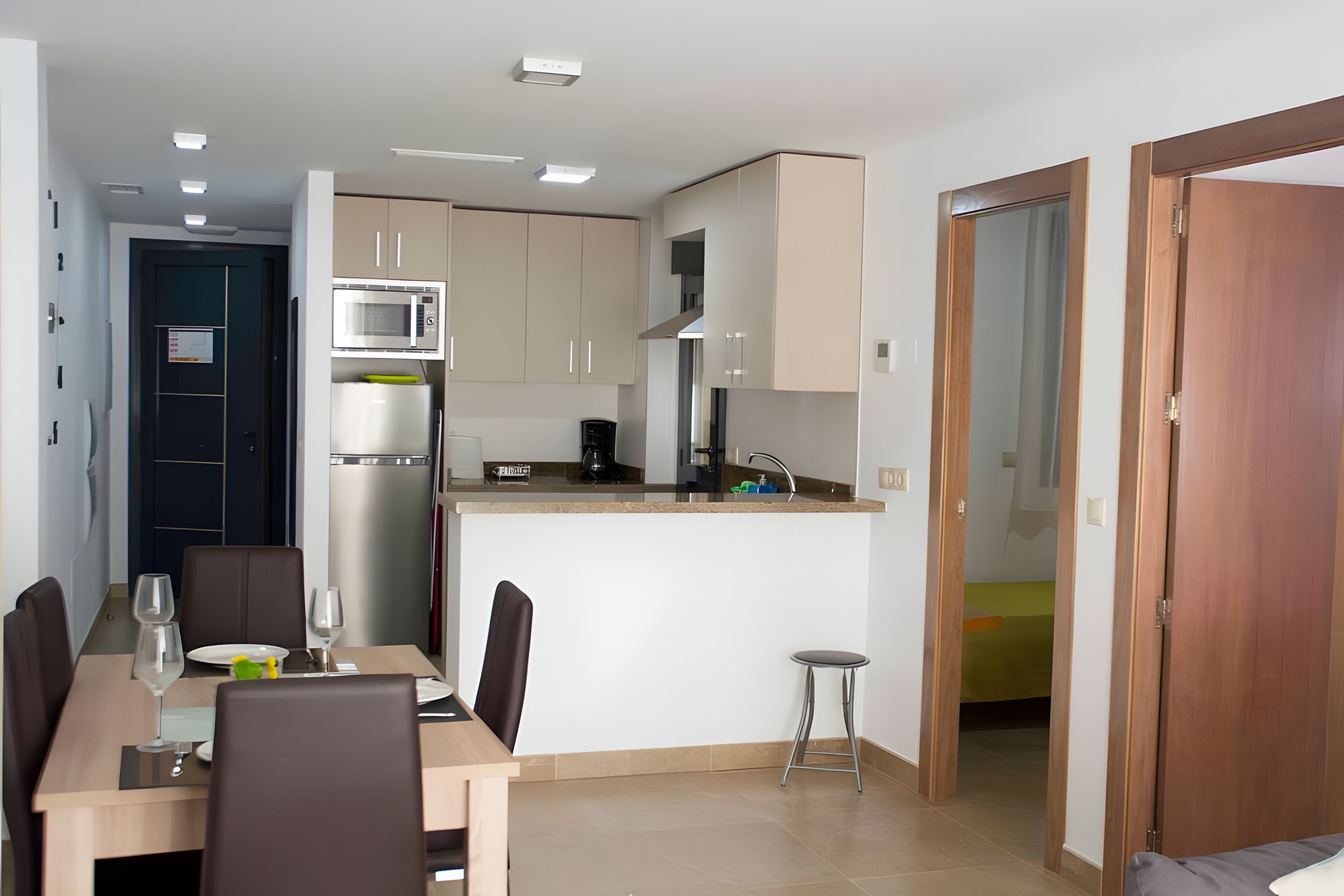Una cocina moderna con microondas integrado, cafetera y lavamanos.