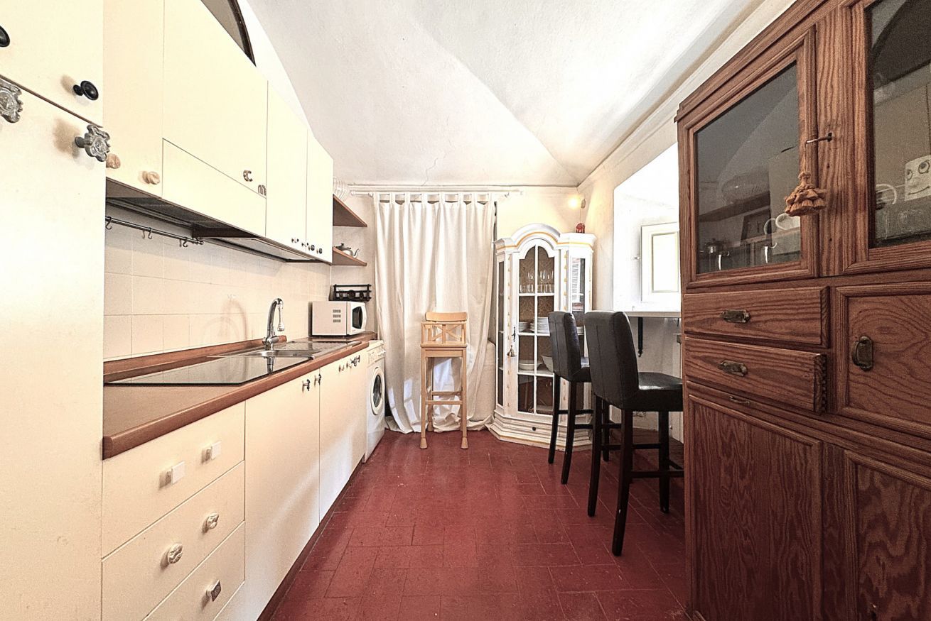 Una cucina funzionale con forno a microonde, lavandino e pensili in legno.