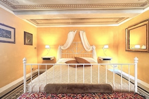 A bedroom with a four-poster bed, two bedside tables, and a large mirror on the wall. - T. R. B. Home - Piazza Gramsci (Siena)