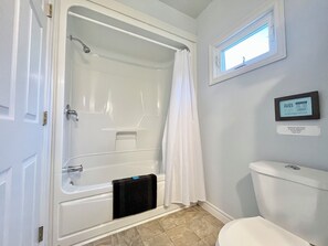 A bathroom with a bathtub, toilet, and a window. - Cozy Chalet #5/ Heated Pool/ Close To Beach/ On Site Activities! (Brackley Beach)