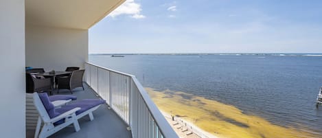 Een balkon met lounge stoelen, een tafel en uitzicht op zee.
