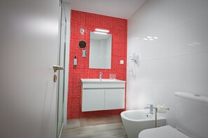 A modern bathroom with a red tiled wall, a white sink, a mirror, and a white toilet. - Holiday Home 'Casa Morango - Senhora Da Rocha' with Sea View, Wi-Fi and Air Conditioning (Porches)