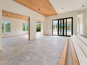 A spacious interior with large windows, a wooden ceiling, and a view of the outdoors. - La Piscina Luxury Retreat with Private Heated Pool, Spa and Putting Green (Pensacola)