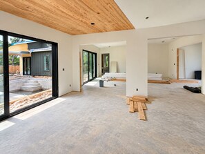 A modern interior with a concrete floor, large windows, and a wooden ceiling. - La Piscina Luxury Retreat with Private Heated Pool, Spa and Putting Green (Pensacola)