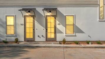 A two-story building with a flat facade, large windows, and a central entrance with a door and two side entrances.