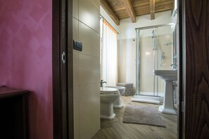 Ein Badezimmer mit Dusche, zwei Toiletten, einem Teppich und einer Holzbalkendecke.
