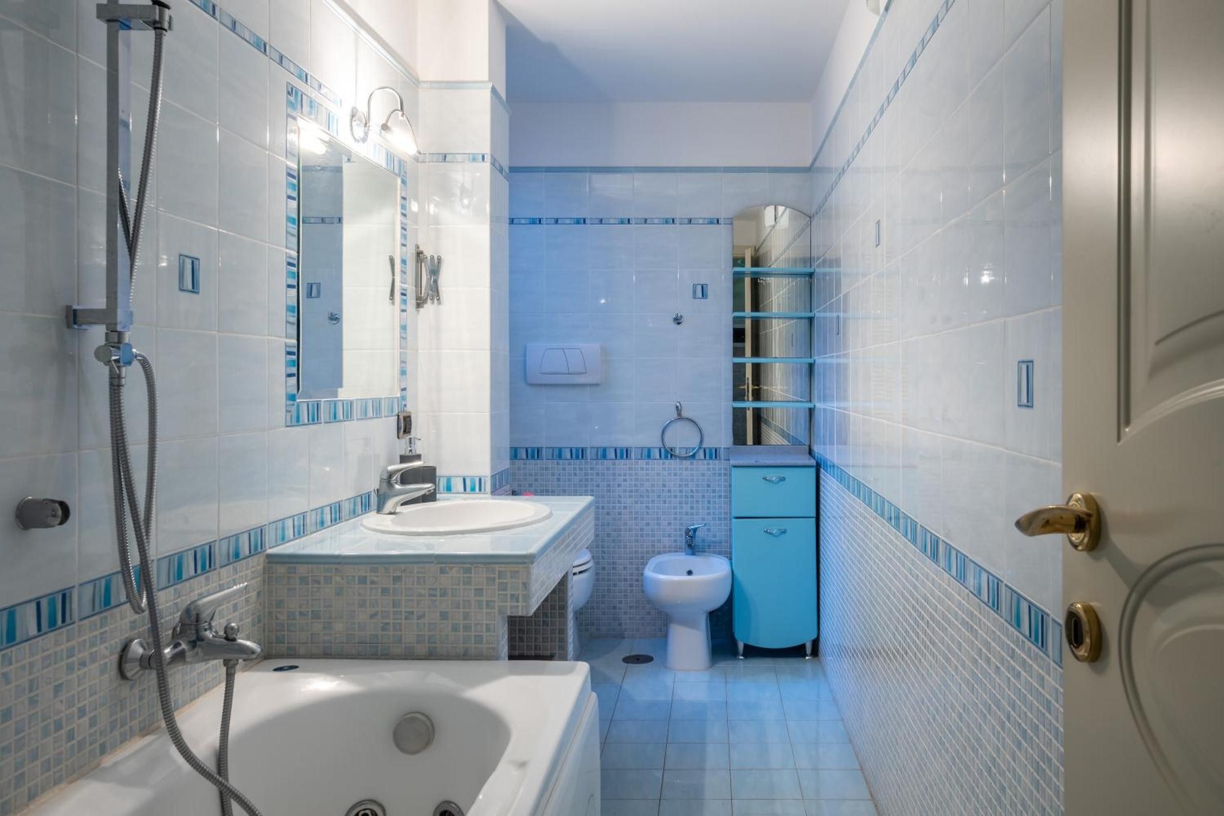 Un bagno con vasca, lavabo, bidet e specchio.