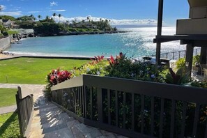 A balcony with a view of a beach and ocean.