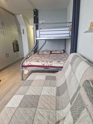 A compact room with a bunk bed, a kitchenette with an oven, and a sofa. - New Listing (Bagnières de bigorre)