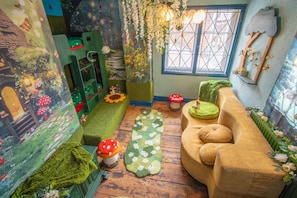 Um quarto aconchegante com um sofá verde, uma mesa pequena e uma janela com vista.