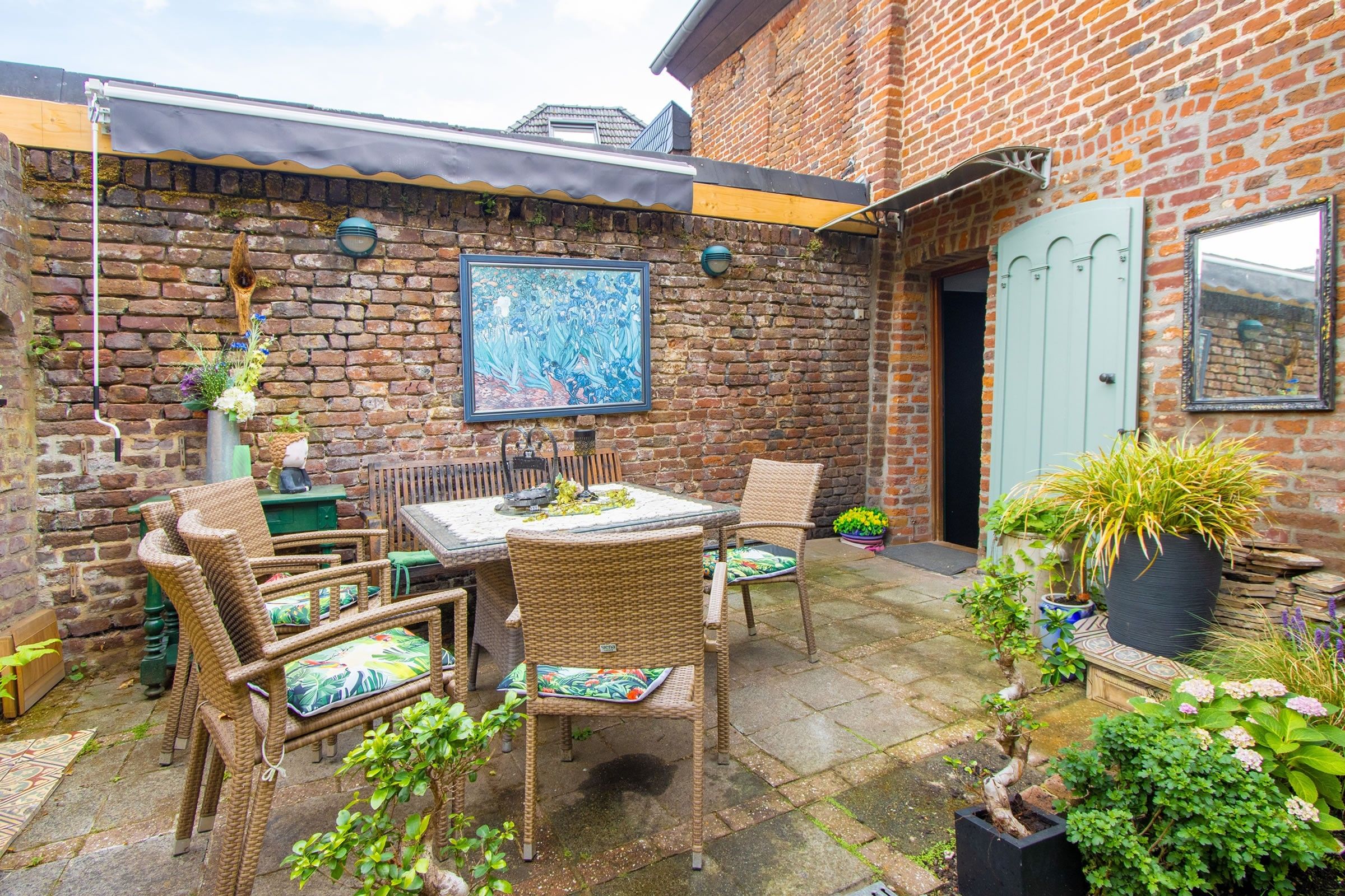 A brick patio with outdoor furniture, a table, and chairs.