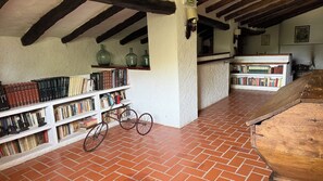 Eine Bibliothek mit Bücherregalen, einem Fahrrad und einem Backsteinboden.