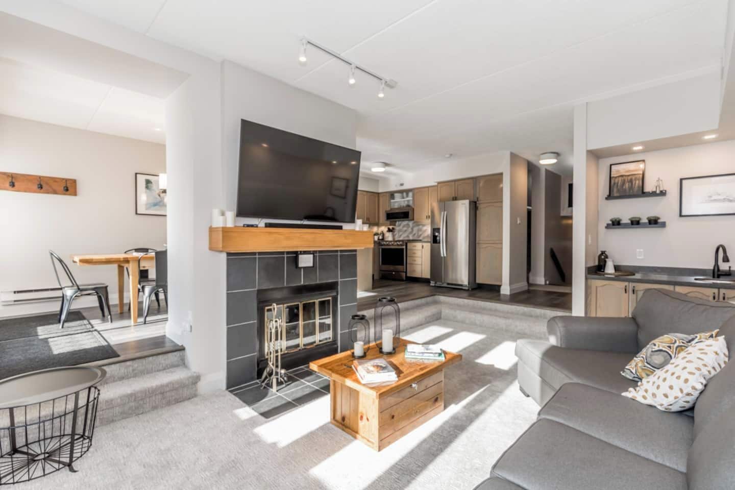 A modern living room with a fireplace, a flat-screen TV, and a sofa.