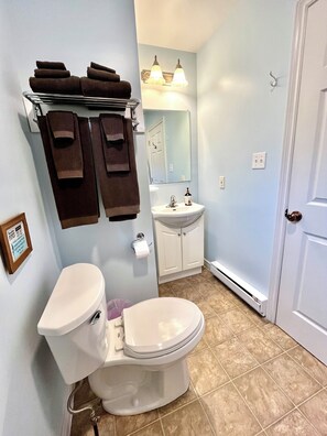 A bathroom with a toilet, sink, and towel rack. - Cozy Chalet #8/ Heated Pool/ Close To Beach/ On Site Activities! (Brackley Beach)