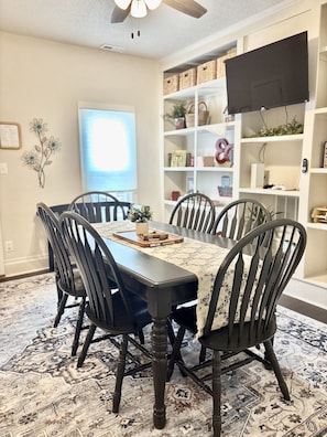 Un comedor con una mesa, sillas y un tapete estampado.