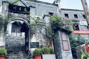 Un edificio tradicional con fachada de piedra, puerta de madera y un letrero.