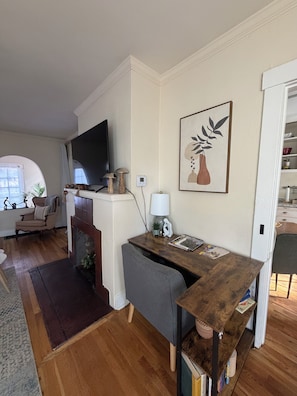 A living room with a fireplace, a television, a dining area, and a bookshelf. - 3- bedrooms residential home (Albuquerque)