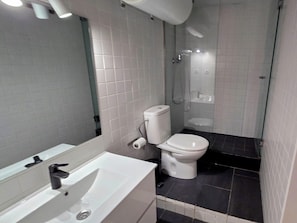 Ein Badezimmer mit Toilette, Waschbecken und Dusche.