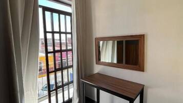 A room with a window, a bench, and a mirror on the wall.