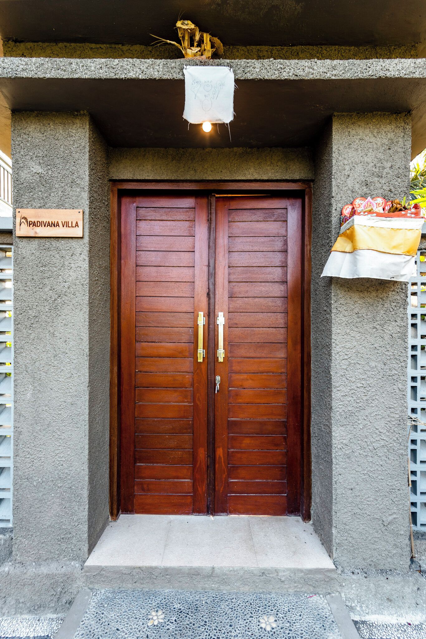 A double wooden door with a sign above it reading 'PADIVANA VILLA'.