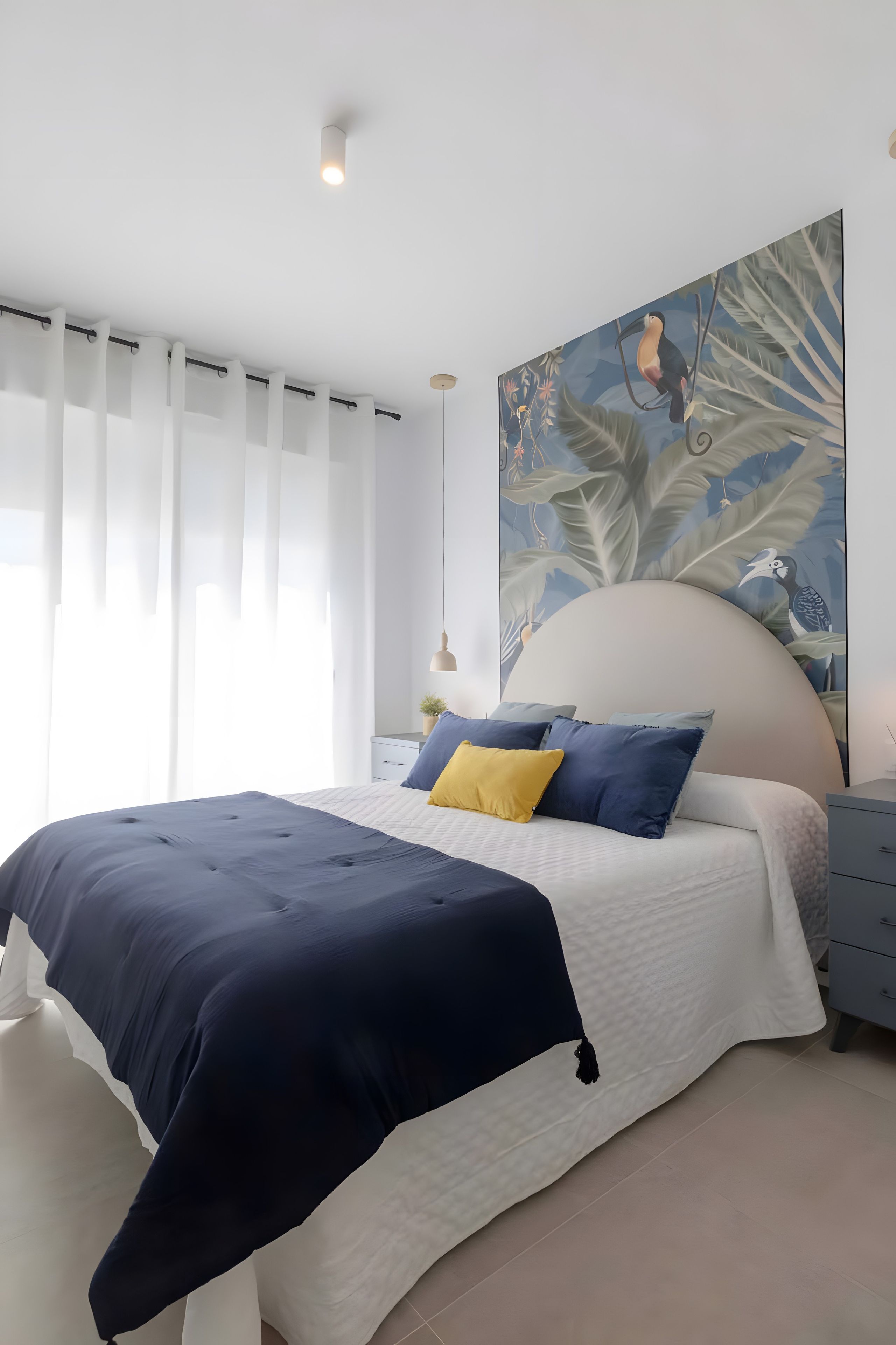 Une chambre à coucher moderne avec un grand lit, une tête de lit, une table de chevet et un luminaire fixé au mur.