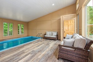 Quarto com piscina, móveis de vime e janelas amplas.