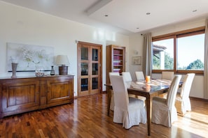 Un comedor con una mesa de madera, sillas y una estantería.