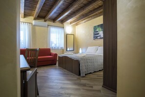 A bedroom with a wooden ceiling, a bed with a grey blanket, a red chair, and a window with curtains. - New Listing (Malvagna)