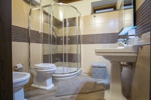 Un baño moderno con ducha de vidrio, inodoro y lavamanos.