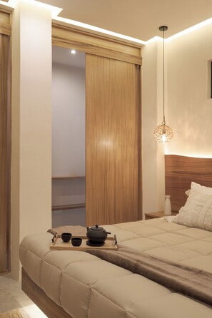 A bedroom with a bed, bedside table, and a nightstand. - OTONONOMUS TOWER (Tulum)