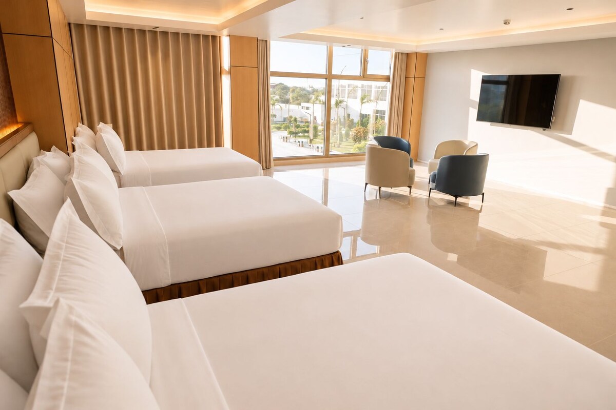 Ein Hotelzimmer mit einem großen Bett, einem Fernseher und Blick ins Freie.