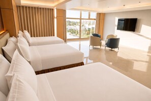 Ein Hotelzimmer mit einem großen Bett, einem Fernseher und Blick ins Freie.