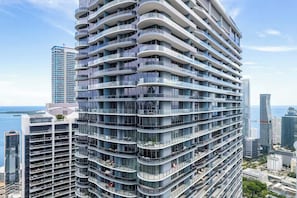 A high-rise building with multiple balconies, large windows, and a view of the sea. - Terrific 3-bedroom apartment with AC in vibrant Miami (Miami)