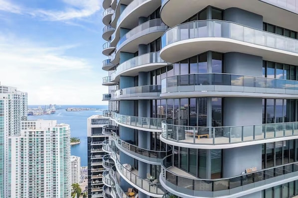 A high-rise building with multiple balconies, large windows, and a view of the sea. - Terrific 3-bedroom apartment with AC in vibrant Miami (Miami)