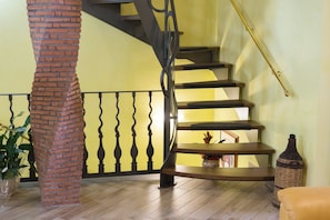 Eine Treppe mit einer Ziegelstütze und einem schmiedeeisernen Geländer.