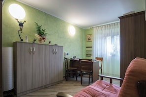 Ein kompakter Wohnraum mit Küchenzeile, Essbereich und Sitzecke.