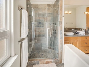 A modern bathroom with a glass-enclosed shower, a large sink, and wooden cabinets. - The Mountain Retreats (Newbury Park)