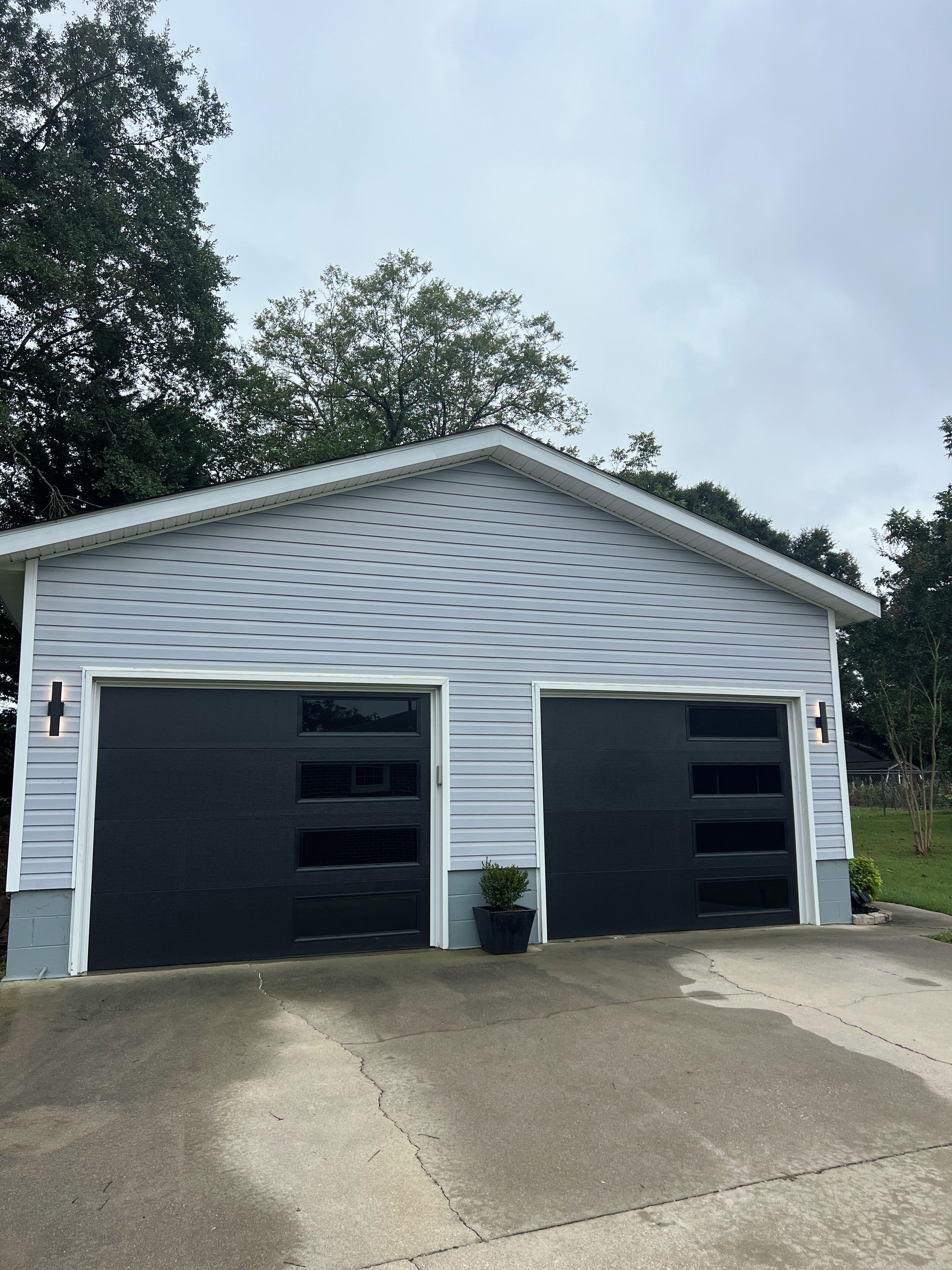 A two-car garage with a sloped roof and a concrete driveway.