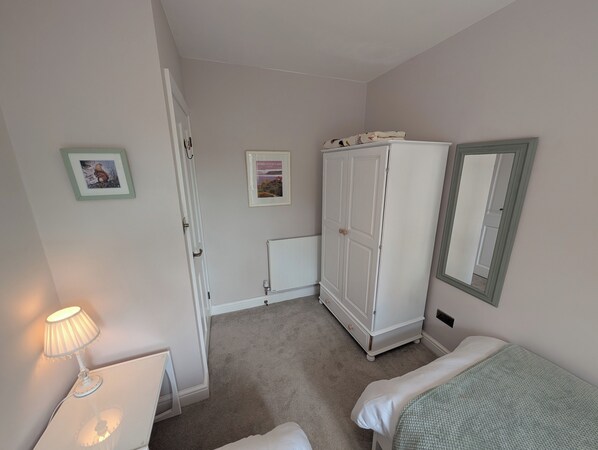 A bedroom with a bed, a wardrobe, a radiator, and a lamp. - Charming Yorkshire Cottage | Log Burner | Dog Friendly | Near Malton (Brawby)