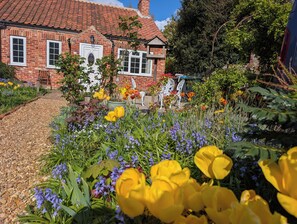Une maison en briques avec un chemin de jardin menant à l’entrée.
