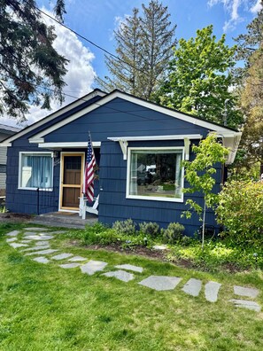 A single-story house with a dark blue exterior, a front door, and a small porch. - The Blackberry Cottage 2-bedroom house in beautiful Bend for relaxing stays! (Bend)