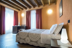 Ein Schlafzimmer mit Bett, Nachttischlampe und Vorhängen.