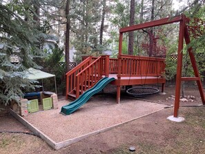 Ein Spielplatz mit Rutsche und Schaukel.